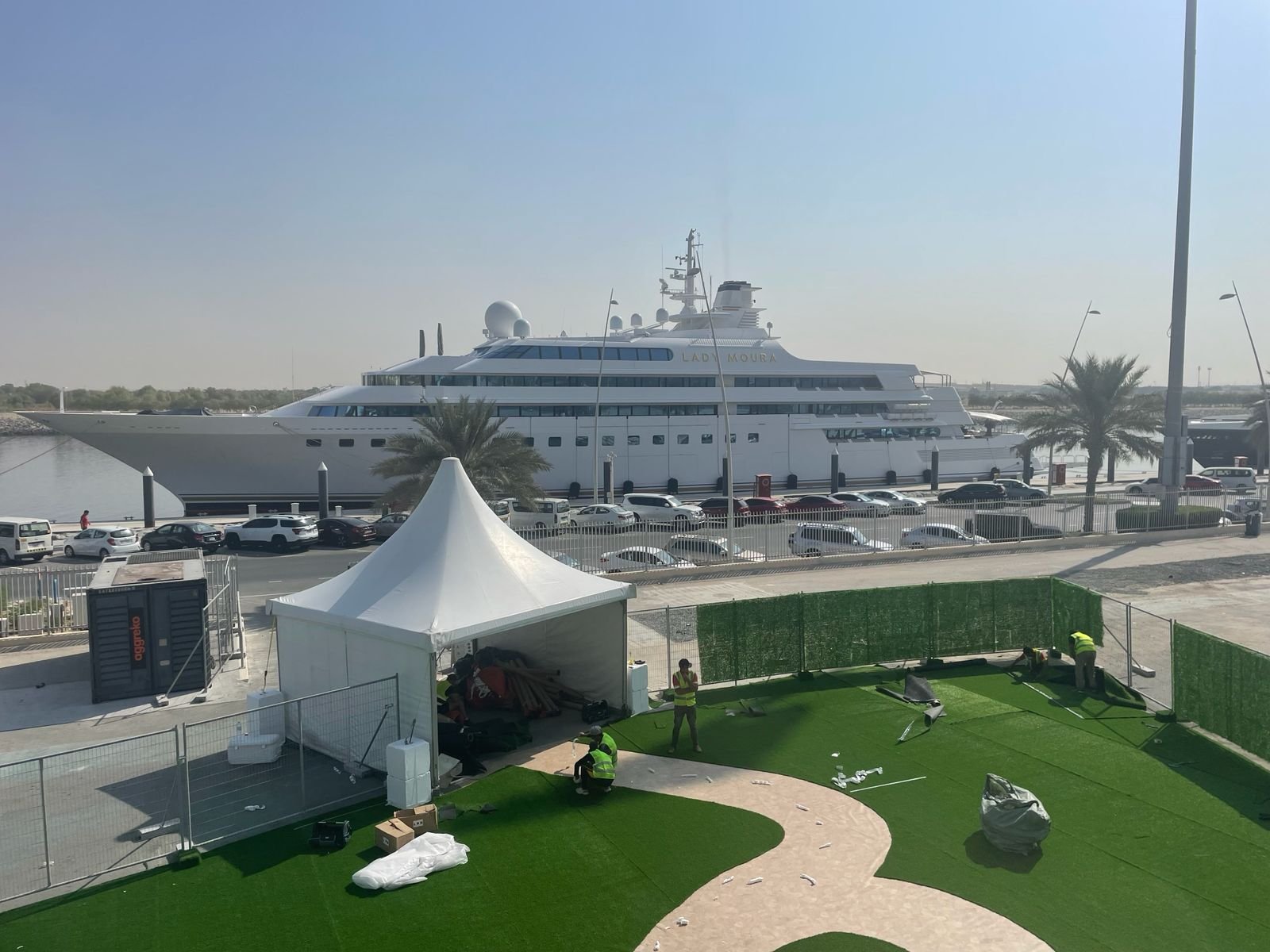 Pagoda tent installation on the marina with a superyacht in the background