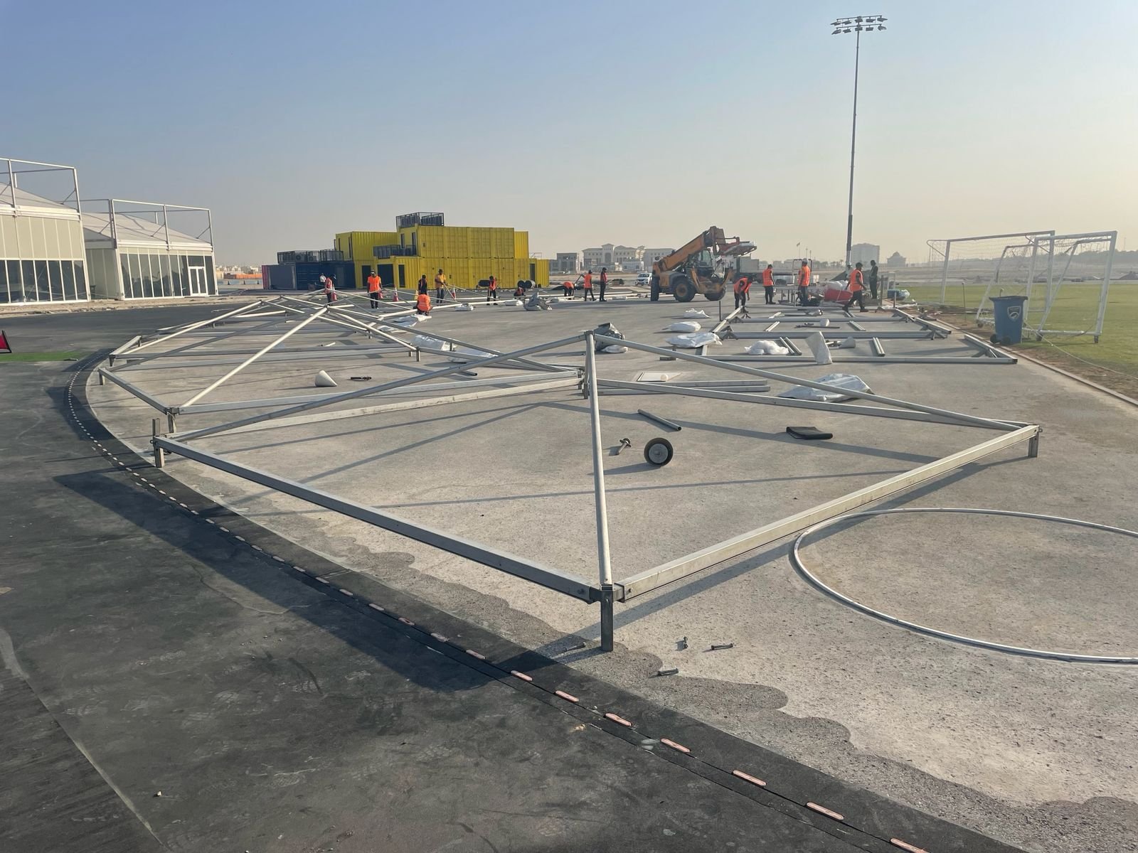 Aluminium tent framework being assembled on a sports ground